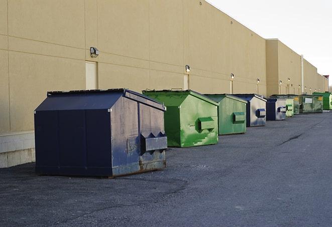 a compact construction dumpster being emptied by a waste disposal truck in Cedar Grove NJ